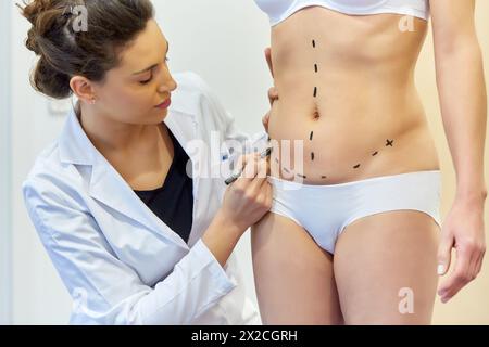 Abdomen. Tummy tuck. It is retensioning skin and abdominal muscles, by removing redundant skin and musculature plication. Before surgery should be tak Stock Photo