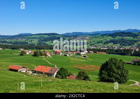 Alpine Foothills Charm: Rural Mountainside Living with Farmer's Homesteads. Mountain Countryside: Farmer's Dwellings, Pastures, and the Sky Above Stock Photo