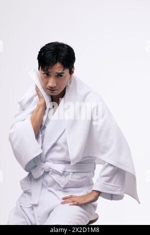 a middle aged man who wipes his face with a white towel Stock Photo