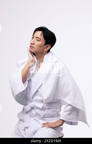 a middle aged man who wipes his face with a white towel Stock Photo