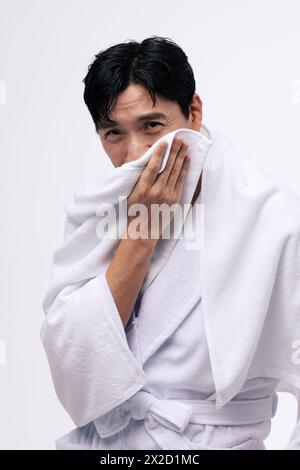 a middle aged man who wipes his face with a white towel Stock Photo