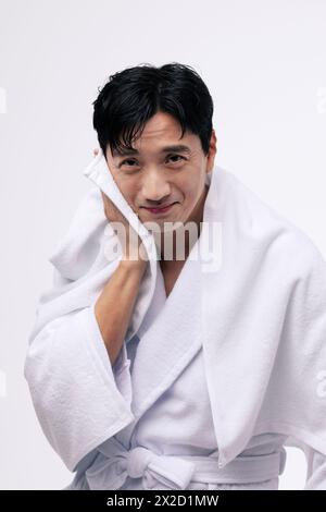 a middle aged man who wipes his face with a white towel Stock Photo