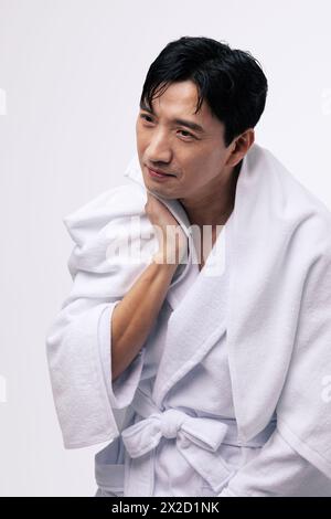 a middle aged man who wipes his neck with a white towel Stock Photo