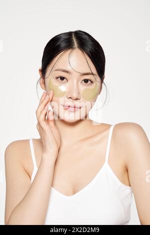 Asian woman posing with eye patches on both cheeks Stock Photo