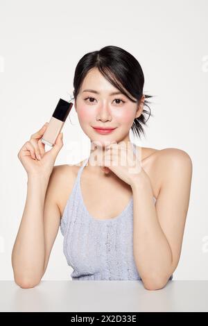 Asian woman staring straight ahead with foundation Stock Photo