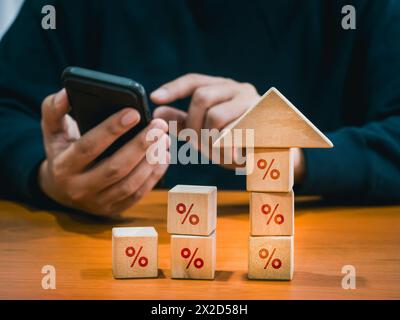 Percentage icon on wooden cube blocks bar graph chart steps with big arrowhead and businessman using mobile phone. Investment online, stock trading in Stock Photo