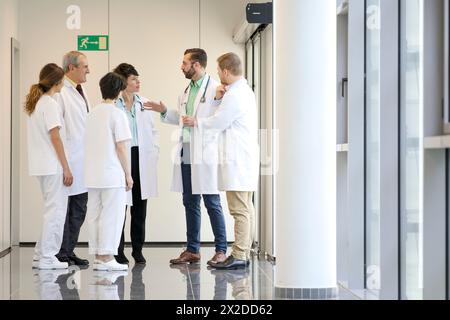 Doctors and nurses talking in corridor, Hospital Stock Photo