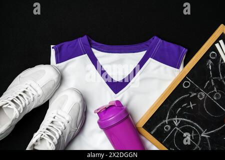 Athletic Gear and Strategy Planning on a Black Background Stock Photo