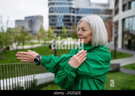 Mature woman stretching before run. Exercising after work for good mental health, physical health, relieving stress and boost mood. Stock Photo