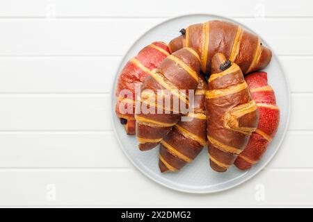 Freshly Baked fruity and Chocolate Croissants on plate on a kitchen table. Top view. Stock Photo