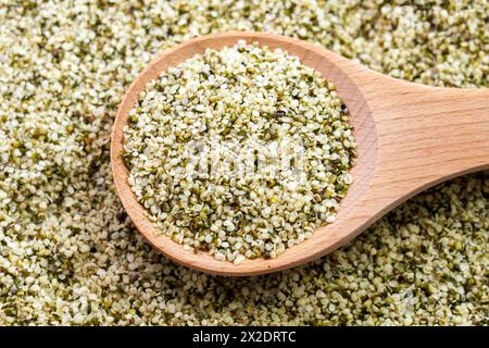 Hemp seeds in rustic wooden spoon close up. Peeled nutritious Cannabis sativa grains. Superfood ingredient. Stock Photo