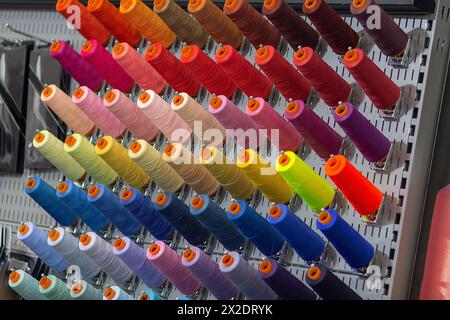 Multi-colored threads on a stand close-up. Clothing industry Stock Photo