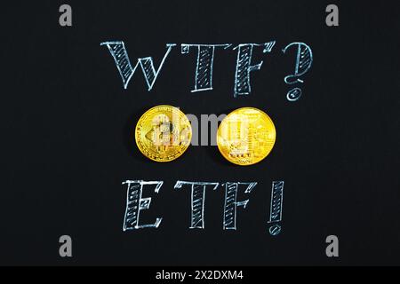 Two bitcoins and the inscription ETF in chalk close-up on a black background. Cryptocurrency, virtual reality, coin of the future. Stock Photo