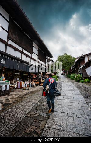 Traditionally dressed Japanese postman delivering the mail, Nakasendo Way, Japan. Stock Photo