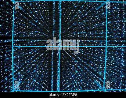 Rain of light blue drops of light falling off the sky at night. Artificial rainfall or precipitation made of lights resembles artificial intelligence Stock Photo