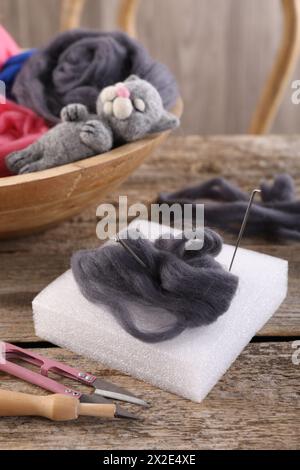 Felting tools, wool and toy cat on wooden table Stock Photo