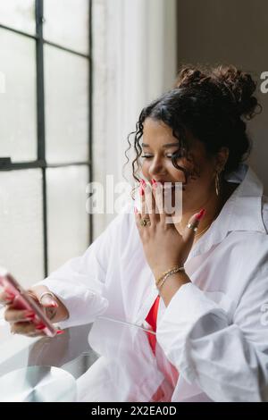 Woman taking on phone reacting to message Stock Photo