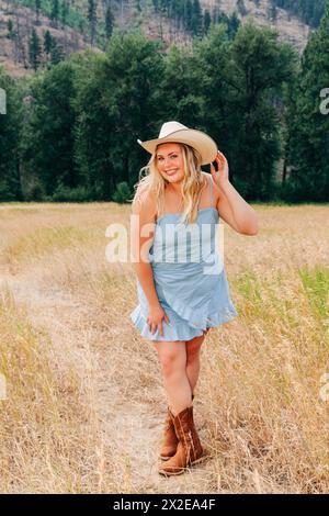 Teenage girl in western sundress, cowgirl hat, and boots Stock Photo