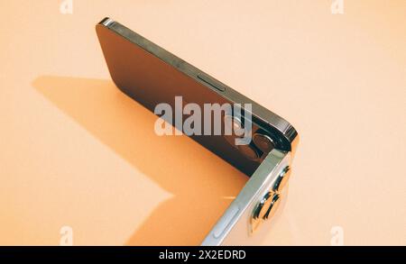 London, United Kingdom - Sep 29, 2022: Two smartphones from Apple's professional titanium line are aesthetically arranged against a vibrant, colorful background Stock Photo