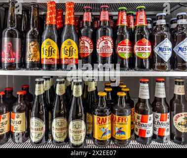 Italy - april 04, 2024: Beer in glass bottles of various types and brands in refrigerated counter. Italian, Sicilian and Sardinian beers and Leffe bee Stock Photo