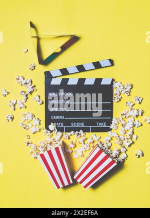 Movie clapperboard and popcorn on yellow background.           Conceptual of cinema, entertainment, audiovisual Stock Photo