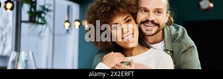 A man tenderly holds a woman in his arms, their connection palpable amidst the modern cafe ambiance. Stock Photo