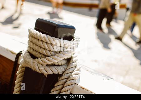 Close-up of old rope on a sailboat deck. Blurred marina on a background. Selective focus. Stock Photo