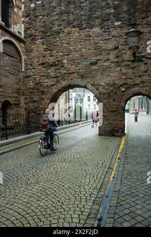 Woman cycles towards the St Servaasbasiliek. Arches at west end of St Servatius Basilica in Maastricht, Limburg, The Netherlands Stock Photo