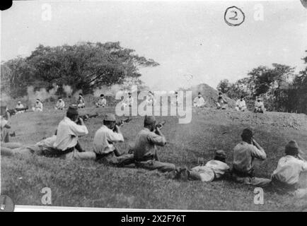ATROCITIES CARRIED OUT BY JAPANESE FORCES DURING THE SECOND WORLD WAR - Japanese soldiers shooting Sikh prisoners who are sitting blindfolded in a rough semi-circle about 20 yards away Stock Photo