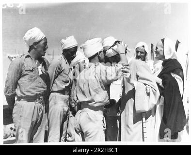 VISIT TO ITALIAN PRISONER OF WAR CAMP - A Libyan prisoner kissing the turban of Sayed Idris British Army Stock Photo
