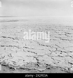 DEFENCES IN THE QUATARA DEPRESSION - The Quatara Depression lies about about thirty miles South of El Alamein and forms a natural obstacle for an advancing army in that it is composed of soft sand, bogs and salt flats impassable to motorised transport. This salt lake in the Quatara Depression illustrates the almost impassable nature of the ground Stock Photo