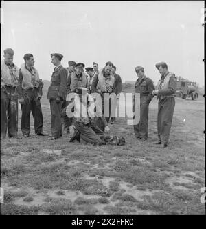 AMERICANS IN BRITAIN: THE WORK OF NO 121 (EAGLE) SQUADRON RAF, ROCHFORD, ESSEX, AUGUST 1942 - Men of No 121 (Eagle) Squadron stand and wait for their call to action on the grass at Rochford airfield. Left to right they are: Flying Officer K M Osbourne, Squadron Leader W B Williams DFC (the Commanding Officer), an unidentified English officer of the ground staff, Pilot Officer Don A Young, Pilot Officer Frank R Boyles, an unidentified squadron member, Flight Lieutenant Seldon R Edner, Flight Sergeant Jim Sanders, an unidentified squadron member, Pilot Officer Jim Happel and another unidentified Stock Photo