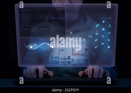 Close-up of a man's hands on a laptop keyboard and virtual screen with medical, biological and scientific icons. Concept of medical and biological sci Stock Photo