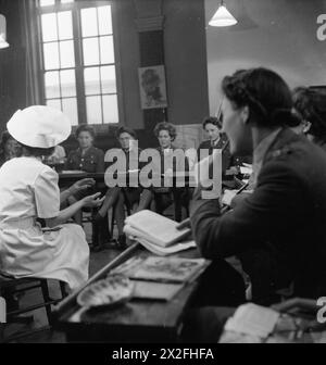 ATS DOMESTIC SCIENCE COURSE IN NOTTING HILL GATE, LONDON, 1944 - Chief instructor, Mrs Evans, talks to a class of girls on one of the Domestic Science Courses given to members of the Auxiliary Territorial Service (ATS) by the London District of the Army Education Scheme. The course was run in the Domestic Science block of London County Council's Avondale Park School in Notting Hill Gate British Army, Auxiliary Territorial Service Stock Photo