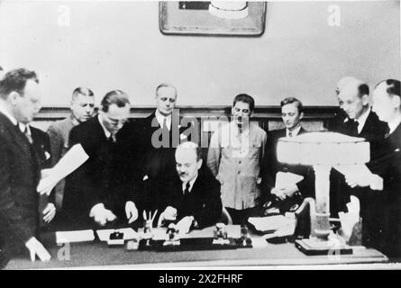 THE NAZI-SOVIET NON-AGGRESSION PACT (THE RIBBENTROP-MOLOTOV PACT) - The Soviet Minister for Foreign Affairs, Vyacheslav Molotov, signs the Nazi-Soviet Non-Aggression Pact (also known as the Molotov-Ribbentrop Pact) in the presence of the German Foreign Minister, Joachim von Ribbentrop and the Soviet leader Josef Stalin (both standing immediately behind), in Moscow, 28 September 1939 Molotov, Vyacheslav Mikhailovich, Stalin, Joseph, Ribbentrop, Joachim von, Shaposhnikov, Boris Mikhailovitch Stock Photo