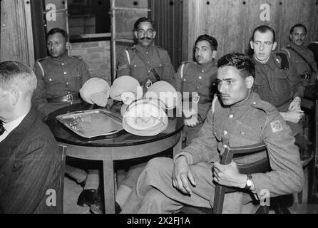 EMPIRE - AND WORLD - PARTY: RADIO BROADCAST FROM THE OVERSEAS CLUB, ST JAMES'S LONDON, 1942 - Private Mobed Shaffi of the Royal Indian Army Service Corps (RIASC) listens to the broadcast with some of his fellow soldiers around a table in the Hall of India Stock Photo