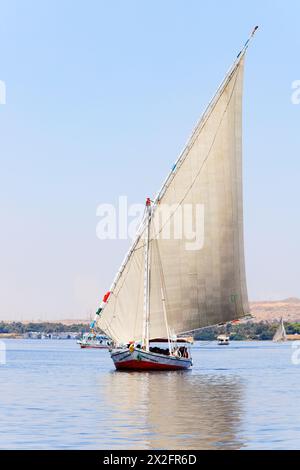 Traditional Arab Egyptian felucca sailing boat with tourists. Aswan harbour, River Nile, Egypt Stock Photo