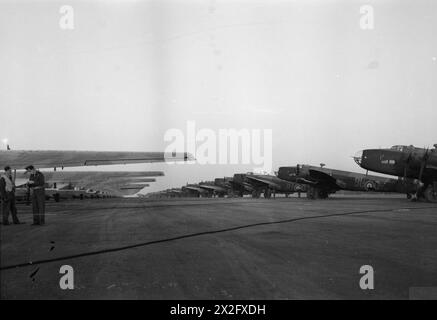 ROYAL AIR FORCE: FIGHTER COMMAND, NO. 38 (AIRBORNE FORCES) GROUP RAF. - Operation VARSITY. A line of General Aircraft Hamilcars (left) with their tow ropes attached to Handley Page Halifax A Mark VII glider tugs of Nos. 298 and 644 Squadrons RAF, lined up at Woodbridge, Suffolk, before the evening take off for the assault on the Rhine Royal Air Force, Expeditionary Air Wing, 34, Royal Air Force, Royal Air Force Regiment, Sqdn, 113, Royal Air Force, Royal Air Force Regiment, Sqdn, 184 Stock Photo