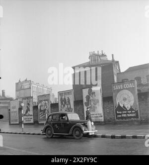 A car passes Ministry of Information campaign posters in Britain, 1942, promoting walking, Dig for Victory, food nourishment, war savings, women's work, and coal conservation. Stock Photo