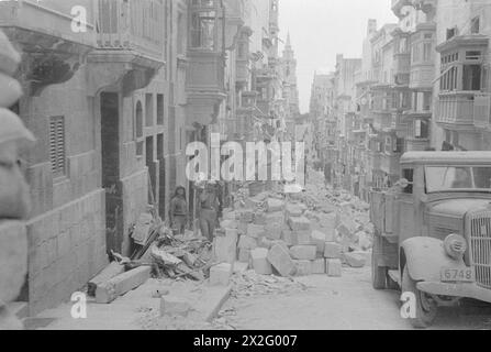 Emergency workers clear debris and damaged road infrastructure near a ...