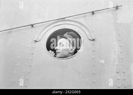 WITH A DESTROYER FLOTILLA AT SEA. AUGUST 1940, ON BOARD SHIPS OF THE FLOTILLA. - The JUPITER's coxswain looks out of a porthole to see what the warning is about Stock Photo