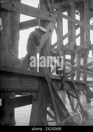 ROYAL NAVY ROAD MAINTENANCE UNIT IN ITALY. MARCH 1945, NORTHERN ITALY. MEN OF A BRITISH NAVAL PARTY WORKING BEHIND THE FIFTH ARMY FRONT MAINTAINING BRIDGES AND KEEPING IN REPAIR ONE OF THE MAIN SUPPLY ROADS TO THE FRONT. - Petty Officer T O'Brian of Manchester (left) and Engine Room Artificer E Dunkerley of Glasgow inspecting one of 10 bridges on the supply route Stock Photo