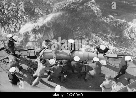 Crew aboard HMS Sheffield hoist in paravanes while escorting a British ...