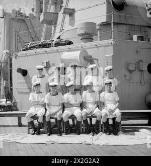 MEN OF THE HMS SUFFOLK, A CRUISER SERVING WITH ADMIRAL JAMES SOMERVILLE'S EASTERN FLEET. 12 DECEMBER 1943, TRINCOMALEE. THE MEN ARE DIVIDED INTO GROUPS BY TOWN AND/OR DISTRICT. - S Wales group. Front row, left to right: E H Davies; RC Turpin; V Rogers; E Brooman; E Webb. Second row, left to right: N Norman; G Carpenter; R Hough; B Gale; G Lynch Stock Photo
