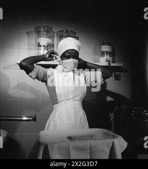 Nurse Ademola, a trainee, adjusts her protective mask before entering the maternity ward at Guy's Hospital to care for mothers and infants. Stock Photo