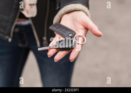 Transfer Of Car Keys In Female Handsl, Black Jacket Stock Photo