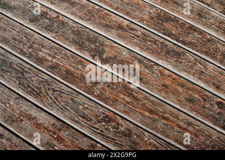 Brown grunge wooden planks as background, diagonal lines. Texture of an old wooden backdrop. Dark brown surface. Stock Photo
