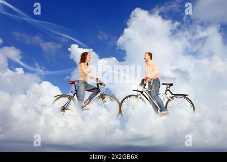 bicycle couple man and woman meeting on dream white clouds collage Stock Photo