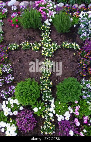 Spring Easter flowerbed with a cross of flowers Stock Photo