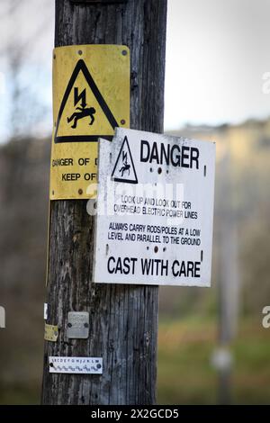 ELECTRICITY DANGER OF DEATH WARNING SIGN ON POLE RE FISHERMEN CHILDREN WARNINGS FISHING RODS CASTING WITH CARE SIGNS ETC UK Stock Photo